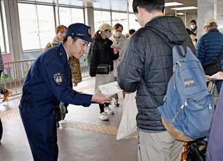 　ＪＲ都賀駅で情報提供を求めるチラシを配る千葉県警の捜査員＝１３日午前、千葉市