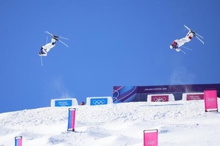 　フリースタイルスキー男子デュアルモーグル決勝で第１エアを決める堀島行真（左）＝リビーニョ（共同）