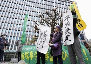 　「飯塚事件」の再審開始が認められず、福岡高裁前で「不当決定」などと書かれた紙を掲げる支援者ら＝１６日