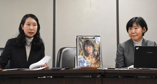 　記者会見する原告側の代理人弁護士。中央の絵は原告の自画像＝２０日午後、東京・霞が関の司法記者クラブ