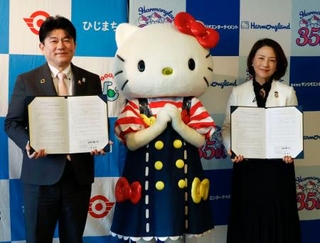 　連携協定を締結し、ハローキティと写真に納まるサンリオエンターテイメントの小巻亜矢社長（右）と大分県日出町の安部徹也町長＝２２日午後、日出町