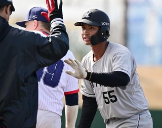 　ＷＢＣチェコ代表との練習試合の５回、安打を放ちコーチとタッチを交わすロッテ・桜井＝都城