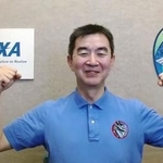 　記者会見で笑顔を見せる宇宙飛行士の油井亀美也さん＝５日午前（ＪＡＸＡの中継から）