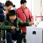 　浜松市役所で期日前投票する袴田巌さん。右は姉ひで子さん＝５日午前