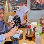 　インドネシア・ジャカルタに開店した「ラーメン・マニア」で、ハラル認証を取得したラーメンを食べるイスラム教徒の女性客ら（ＮＮＡ＝共同）