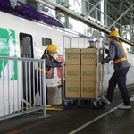 　かご台車を新幹線に載せる係員＝６日午前、盛岡市