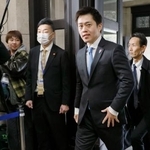 　大阪府庁に登庁する、府知事選で３選を決めた吉村洋文氏（右から２人目）＝９日午前