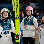 　女子個人ラージヒルを終え、勢藤優花（中央）、高梨沙羅（右）らと笑顔を見せる丸山希＝プレダッツォ（共同）