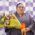 　現役引退の記者会見を終え、花束を手にする元幕内大翔鵬＝１６日、両国国技館
