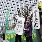 　「飯塚事件」の再審開始が認められず、福岡高裁前で「不当決定」などと書かれた紙を掲げる支援者ら＝１６日