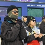 　ミラノ・コルティナ冬季五輪のスノーボード男子スロープスタイルの会場で、手を合わせて見守る長谷川帝勝の父俊介さん（左）＝１８日、イタリア・リビーニョ（共同）