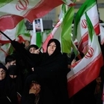 　１７日、イラン体制側がテヘランで催した反政府デモの死者の追悼式典で、国旗を振る女性ら（ＡＰ＝共同）