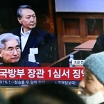 　１９日、ソウル駅のテレビに映し出された尹錫悦前大統領（奥）の判決公判の映像（共同）