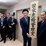 　「国家危機管理室」の看板をかける木原官房長官（右から２人目）＝２０日午前、内閣府