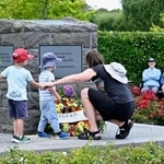 　ニュージーランド地震の犠牲者をしのぶ追悼式で、花を手向ける人たち＝２０日、クライストチャーチ（共同）
