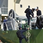 　貨物船に立ち入る運輸安全委員会の船舶事故調査官＝２２日午後、三重県鳥羽市