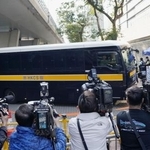 　香港の裁判所に入る、民主派の被告を乗せたとみられる車両＝２３日（共同）　