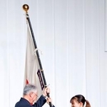 　ミラノ・コルティナ冬季五輪の日本選手団解団式で伊東秀仁団長（左）に団旗を手渡すフィギュアスケートの坂本花織＝２５日午前、東京都内