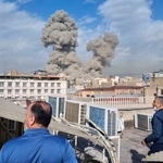 　イランの首都テヘランで爆発後に立ち上る煙を見る人たち＝２８日（ＡＰ＝共同）