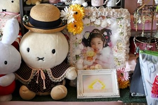 　好きだったキャラクターの人形と一緒に飾られているこりんちゃんの遺影＝２０２５年３月、仙台市