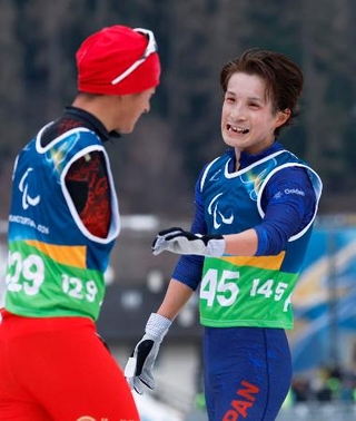 　ノルディックスキー距離男子１０キロ立位のゴール後、健闘をたたえ合う川除大輝＝１１日、イタリア・テーゼロ（共同）