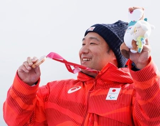 　男子回転座位の表彰式で、銅メダルを手に笑顔を見せる鈴木猛史＝コルティナダンペッツォ（共同）