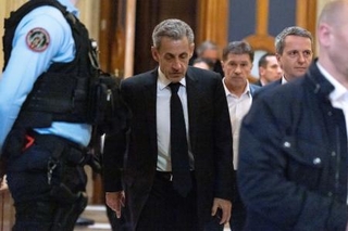 　休廷中に部屋を離れるフランスのサルコジ元大統領（中央）＝１６日、パリ（ゲッティ＝共同）