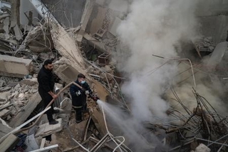 　レバノンの首都ベイルートで、イスラエル軍の空爆後、壊れた建物の火を消す消防士ら＝１８日（ゲッティ＝共同）