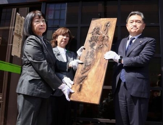 　「もりおか復興支援センター」の閉所式で看板を取り外す金野万里センター長（左）ら＝２８日午前、盛岡市