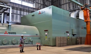 　営業運転を開始した「ひびき発電所」のタービン建屋に置かれたガスタービン（右）と発電機＝３月２４日、北九州市