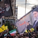 　１日、レバノンの首都ベイルートでの集会で、イラン最高指導者ハメネイ師の旗（右）と、レバノンの親イラン民兵組織ヒズボラの指導者だった故ナスララ師の旗を掲げる人たち（ゲッティ＝共同）