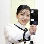 　「第５７回なるほど展」で「防災笛」として使用できるスマートフォンのスタンドを手に取られる佳子さま＝２日午前、東京・有楽町の東京交通会館