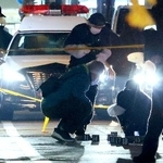 　女性が刺されたと通報があった現場付近の路上を調べる捜査員＝６日午後７時４４分、富山市