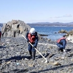 　宮城県南三陸町の沿岸部で、行方不明者の手がかりを求め捜索する警察官＝２０２４年３月