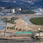 　岩手県陸前高田市の高田地区海岸の巨大防潮堤と災害公営住宅（左上）＝１０日午後