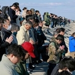 　東日本大震災から１５年、地震発生時刻に合わせて黙とうする人たち＝１１日午後２時４６分、仙台市若林区荒浜地区