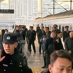 　北京駅で出発を待つ平壌行きの旅客列車と警戒する治安当局者＝１２日（共同）