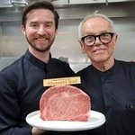 　宮崎牛を持つシェフのウルフギャング・パックさん（右）と息子のバイロンさん＝１２日、米ロサンゼルス（共同）