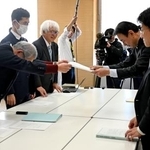 　担当者と面談し、控訴せず早急に患者認定するよう求める要請書を手渡す原告弁護団の弁護士ら（左）＝１７日午後、新潟県庁