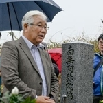 　阪原弘さんの命日に墓参りする長男の弘次さん＝１８日午後、滋賀県日野町