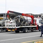 　事故があった新名神高速下り線の野登トンネルから運び出された車両（荷台上の２台）とトラック（右奥）＝２０日午後１時２分、三重県菰野町