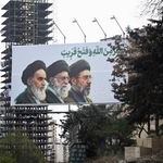 　街頭に掲げられたイランの最高指導者モジタバ・ハメネイ師（右）らの肖像＝２０日、テヘラン（共同）