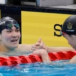 　男子４００メートル個人メドレー決勝のレース後、２位となった小島夢貴（手前）と健闘をたたえ合う優勝した松下知之＝東京アクアティクスセンター