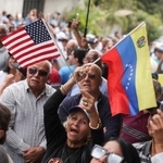 　２８日、ベネズエラの首都カラカスで、野党「ベンテ・ベネズエラ」の本部再開に際し、米国とベネズエラの国旗を掲げる党員ら（ロイター＝共同）