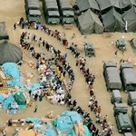 　阪神大震災の避難所となった小学校の校庭で、救援物資の配給に並ぶ被災者の長い列＝１９９５年１月、神戸市東灘区