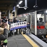 　ＪＲ留萌線の深川駅に到着した最終列車を囲む人たち＝３１日午後１０時４分、北海道深川市