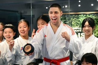 　返還された銅メダルを手に、笑顔で写真に納まるスタニスラフ・ホルナさん＝５日、東京都港区