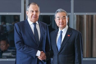 　昨年２月、南アフリカ・ヨハネスブルクでの会談で握手する中国の王毅外相（右）とロシアのラブロフ外相（タス＝共同）