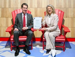 　大阪・関西万博のカナダ館に展示されていた「赤い椅子」に座る関西エアポートのブノア・リュロ副社長（左）＝１３日午前、関西空港