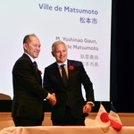 　握手する長野県松本市の臥雲義尚市長（左）とシャンボール国立公園トップのピエール・デュブルイユ氏＝１日午後、東京都港区